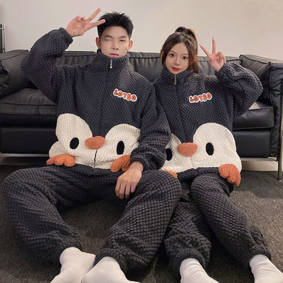 Couple wearing matching fashion casual embossed velvet coral fleece pajamas with cartoon design sitting on floor