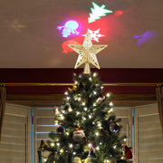 Christmas tree topped with a star-shaped LED laser projector light casting colorful Christmas-themed projections on the ceiling