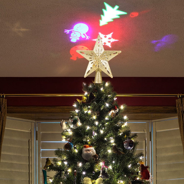Christmas tree topped with a star-shaped LED laser projector light casting colorful Christmas-themed projections on the ceiling